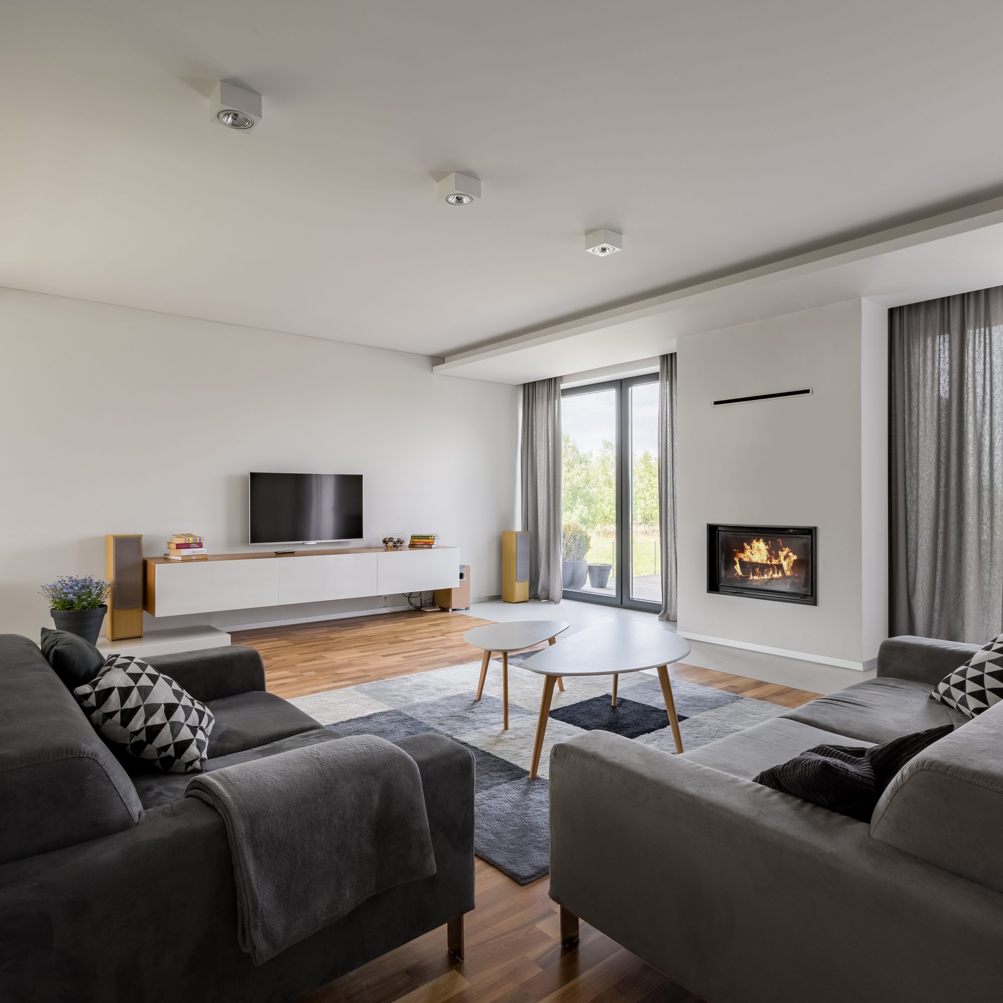A remodeled living room with a dark accent wall, media built-in, and sectional seating