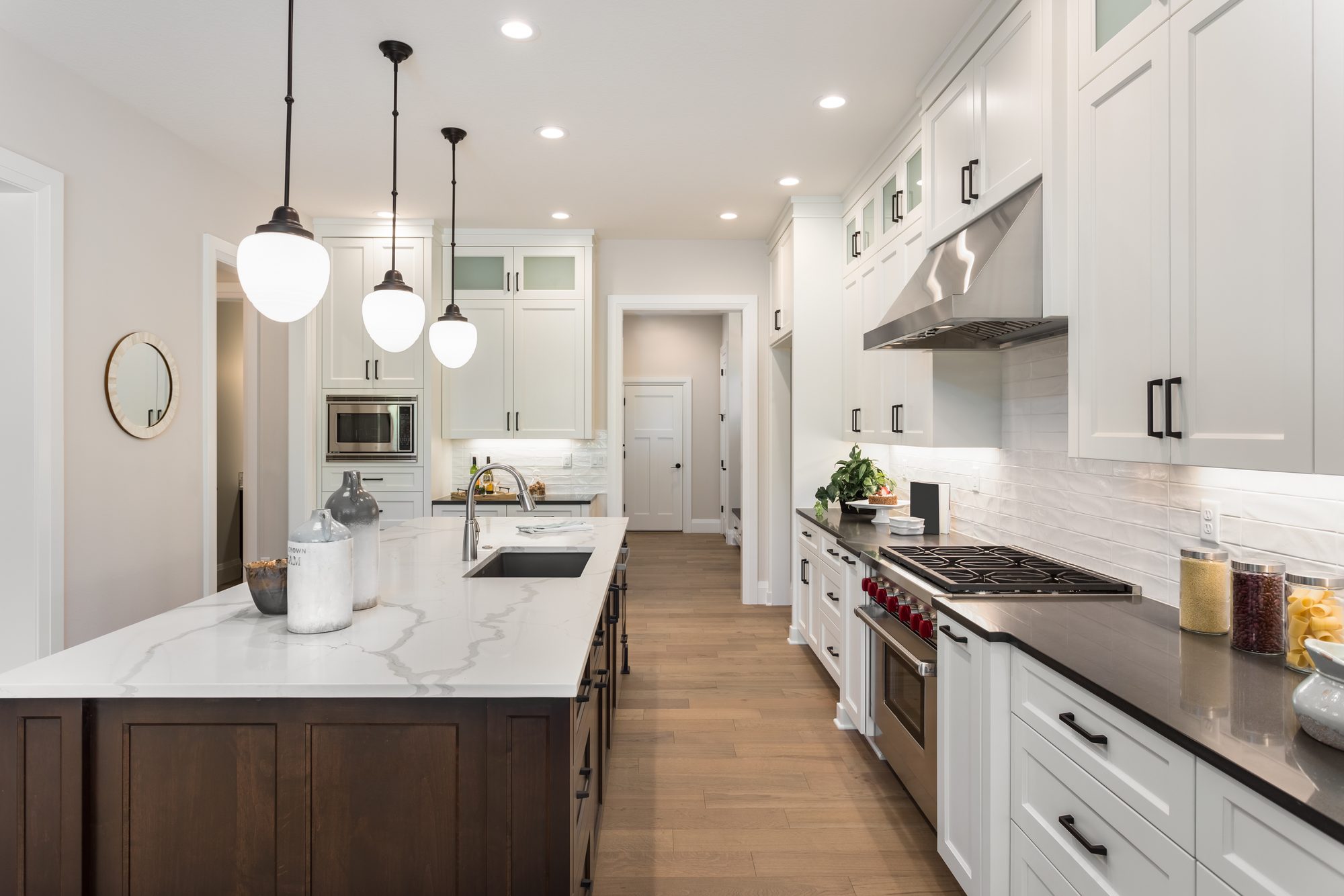 A bright all-white kitchen with hardwood floors