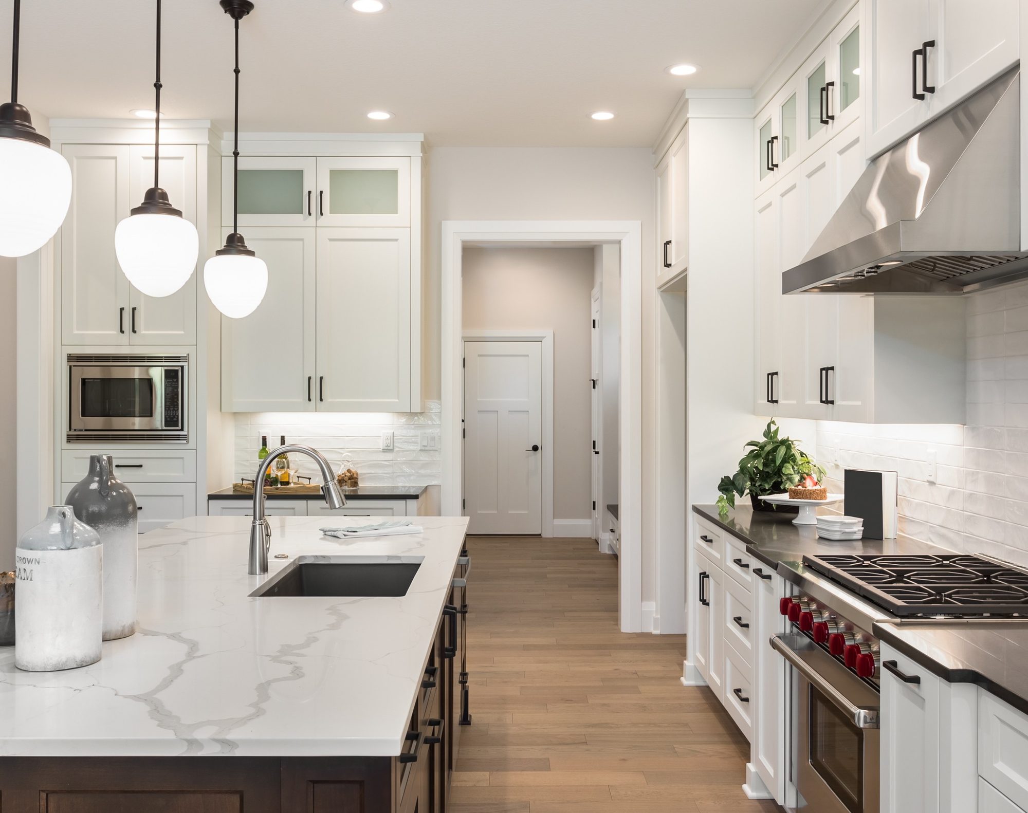 A modern kitchen with a run of glass pendant lights over the island