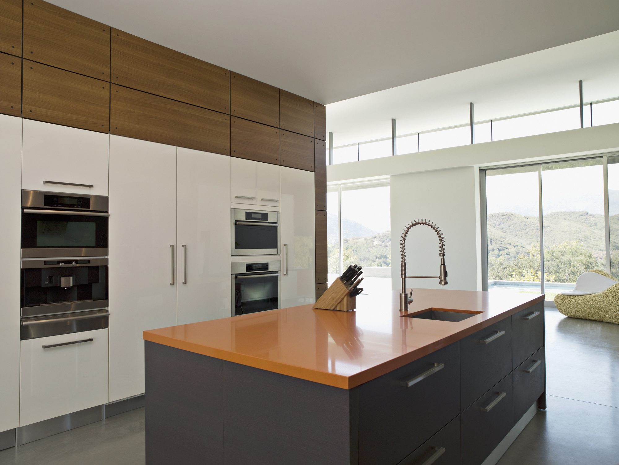 A white shaker kitchen with dark hardwood floors and a black range hood