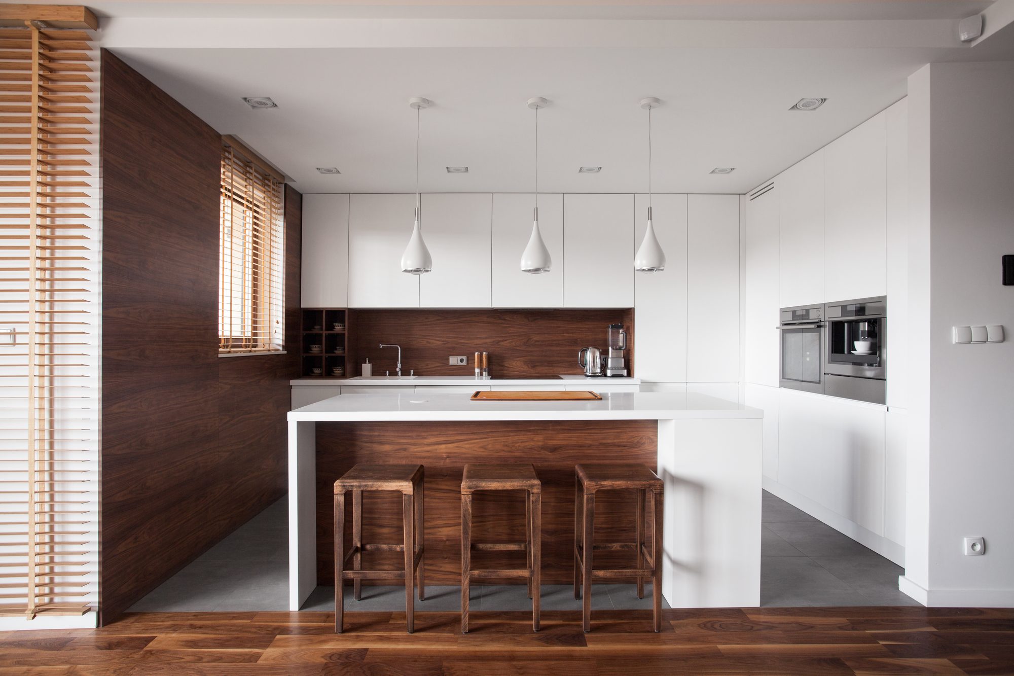 A remodeled kitchen with warm wood cabinetry and stone countertops